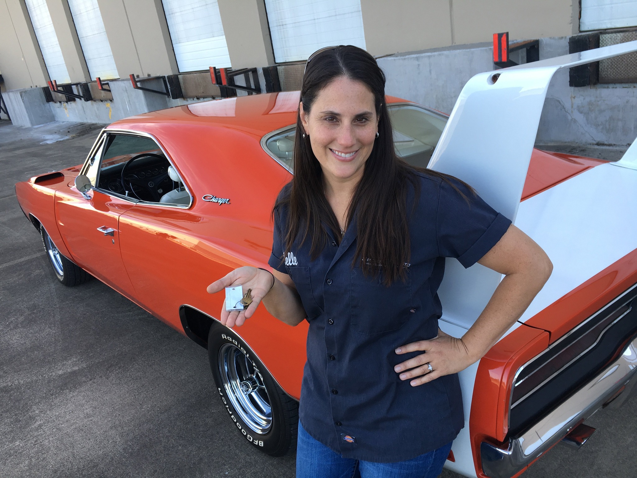Kelle Oeste of the V8 Speed and Resto Shop with the keys to a Charger Daytona